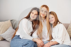 Closeness of the people. Young mother with her two daughters at home at daytime