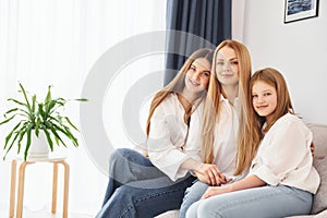 Closeness of the people. Young mother with her two daughters at home at daytime