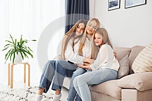 Closeness of the people. Young mother with her two daughters at home at daytime