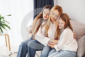 Closeness of the people. Young mother with her two daughters at home at daytime