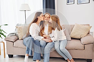 Closeness of the people. Young mother with her two daughters at home at daytime