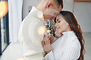 Closeness of the people. Young romantic couple celebrates New year together indoors