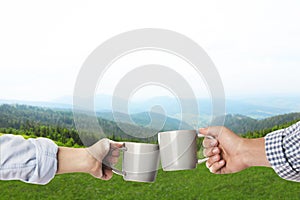 Closeness to nature. Couple with cups in mountains, closeup