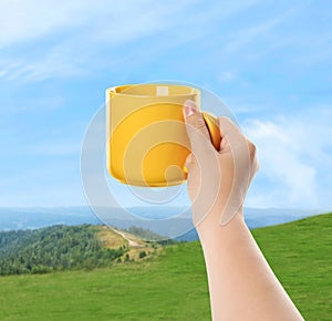 Closeness to nature. Woman holding cup in mountains, closeup