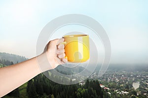 Closeness to nature. Woman holding cup in mountains, closeup