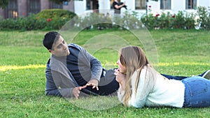 Closer to nature. couple feel free and lie on green grass in the city park. Media. Side view of man and woman friends or