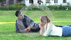 Closer to nature. couple feel free and lie on green grass in the city park. Media. Side view of man and woman friends or
