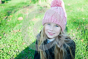 Closesup portrait little girl in hat smile against green grass