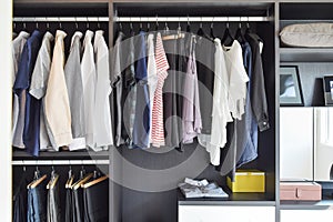 Closet with row of cloths hanging in black wardrobe