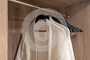 Closet white bathrobes hanging on rack