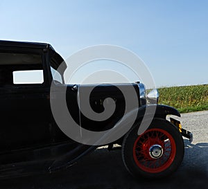 Closeup of 1931 antique car driving by on country road