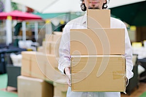 closeup on 3 boxes which man holding, carrying or moving in the store background