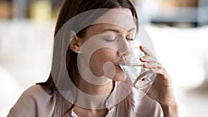 Closeup 30s woman holding transparent glass drinking enough still water