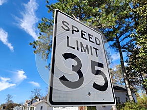 Closeup of 35 speed limit road sign under the blue sky with a blurry background