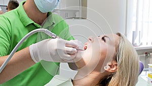Closeup 4k footage of dentist using drill while treating patient`s teeth