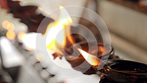Closeup 4k video of sacred flame burning in oil lamps and candles at asian buddhist temple