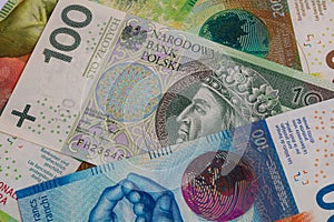 Closeup of 50, 100 and 200 Swiss franc banknotes and 100 polish zloty banknotes