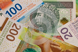 Closeup of 50, 100 and 200 Swiss franc banknotes and 100 polish zloty banknotes