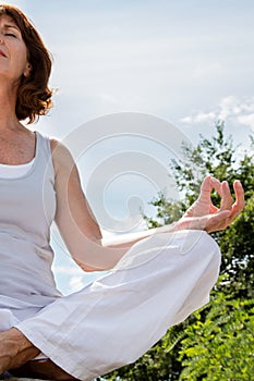 Closeup of a 50s yoga woman sitting in lotus position