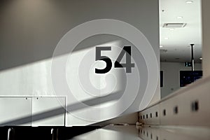 Closeup of a 54 number on a white concrete wall