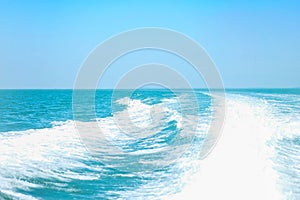 Closeup abstract wave caused by speed boat on blue sea and sky textured background