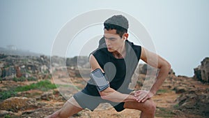 Closeup active man training doing lunges. Fit runner stretching looking camera