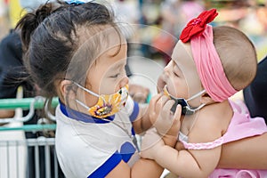 Closeup of an adorable Asian little girl is wearing for younger siste photo