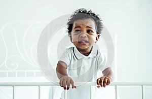 Closeup of adorable little african american baby boy crying on the bed - Black people