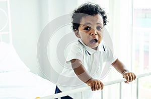 Closeup of adorable little african american baby boy crying on the bed - Black people