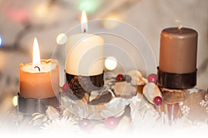 Closeup of Advent wreath with two burning candle and Christmas lights in background