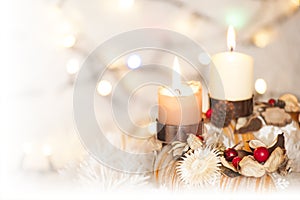 Closeup of Advent wreath with two burning candle and Christmas lights in background