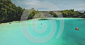 Closeup aerial view of limpid lake on green cliff ocean shore. Indonesia landscape of Weekuri lagoon