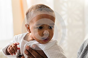 Closeup of African American curious baby boy looking away