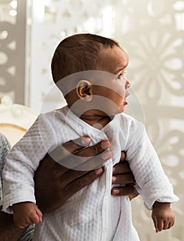 Closeup of African American curious baby boy looking away