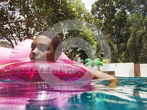 Closeup of african descent woman floating in the pool with inflatable