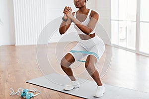 Closeup Of African Woman In Sportswear Exercising With Elastic Band