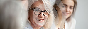 Closeup aged attractive smiling businesswoman listening colleague during briefing meeting