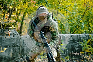 Closeup airsoft man in uniform hold sniper rifle on green forest background photo