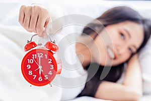 Closeup alarm clock has a nice day with happiness Young asian woman with smile face and healthiness background Beautiful girl hold