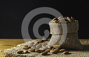 Closeup almonds on wooden texture on dark background with copy space