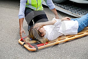 Closeup ambulance and rescue workers helping woman driver from car accident on road