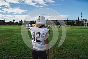 Closeup of an American football player standing on the field.