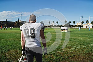 Closeup of an American football player standing on the field.