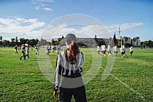 Closeup of an American football referee standing on the field watching the game.