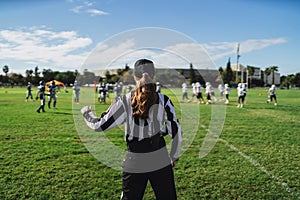 Closeup of an American football referee standing on the field watching the game.