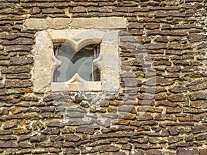 Closeup of ancient stone wall with an interesting square window