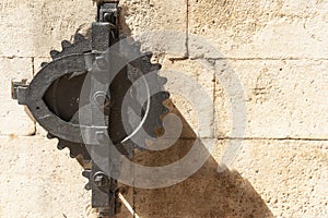 Closeup of ancient toothed iron wheel mechanism used for raising and lowering gate Croatia