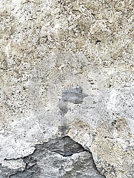 Closeup of ancient wall with plaster falling of the stone structure.
