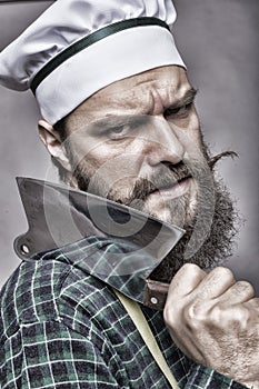 Closeup of an angry bearded man holding a butcher knife
