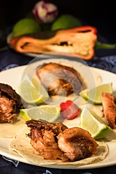 Closeup of appetizer made with tortilla and delicious fried pork rinds on a plate garnished with a tridicional tablecloth with